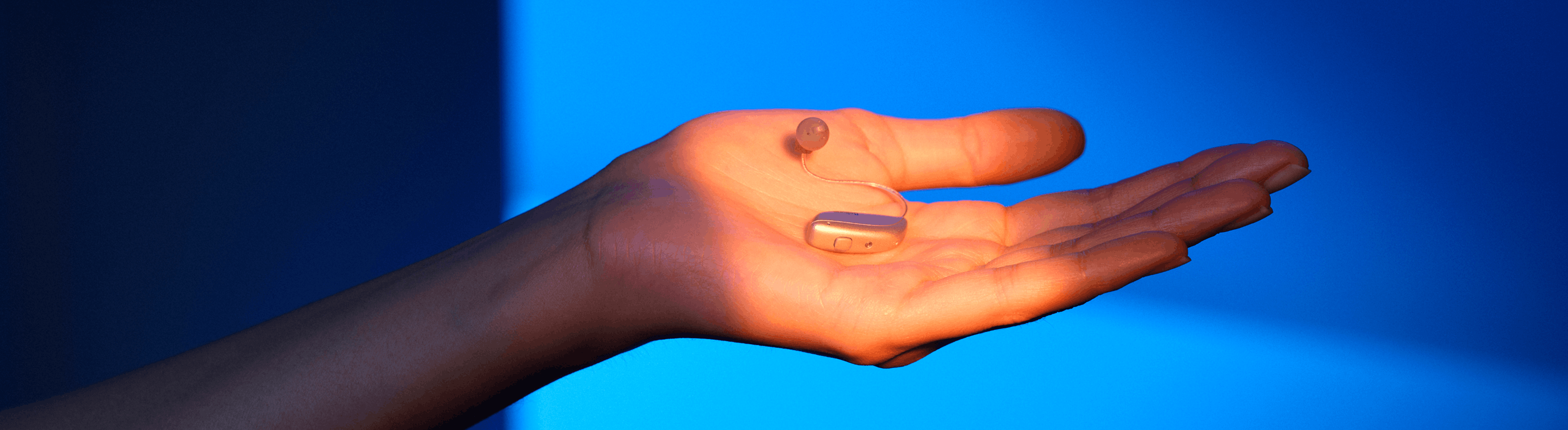 Beltone Illuminate hearing aids laying on an open palm