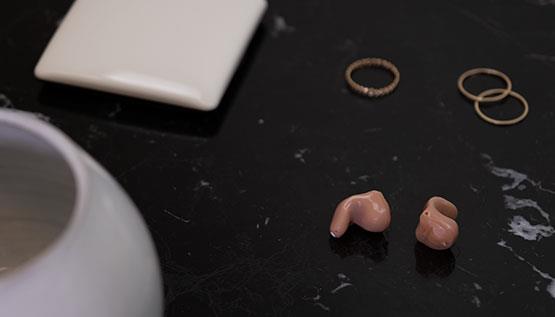 Diskrete, praktisch unsichtbare ReSound Key Hörsysteme auf einem Tisch