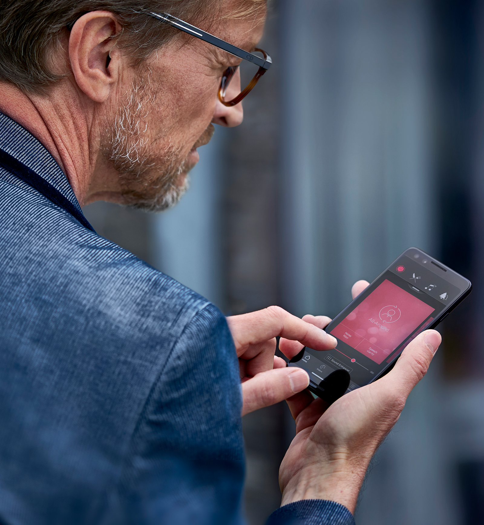 Kvinna som bär ReSound LiNX3D hörapparater och streamar ljud från sin Android-telefon.