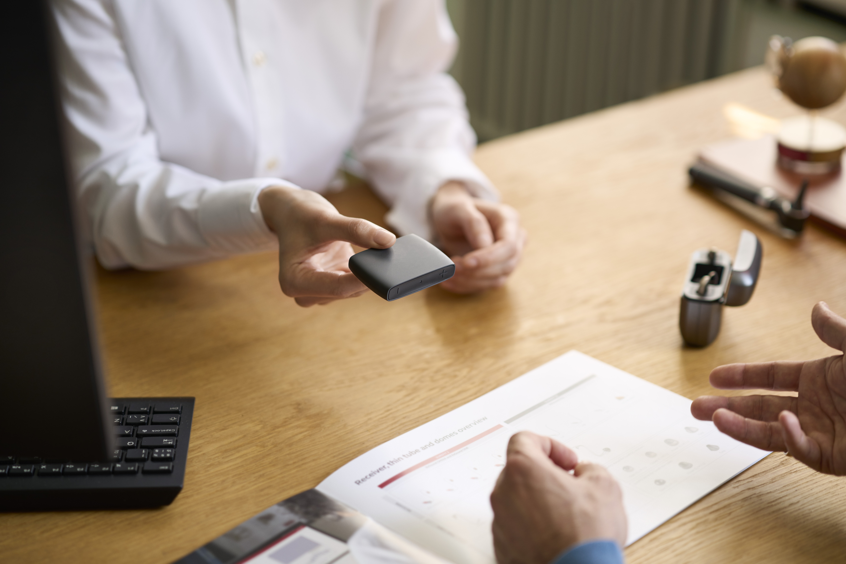 Donna che ripara un apparecchio acustico ReSound.