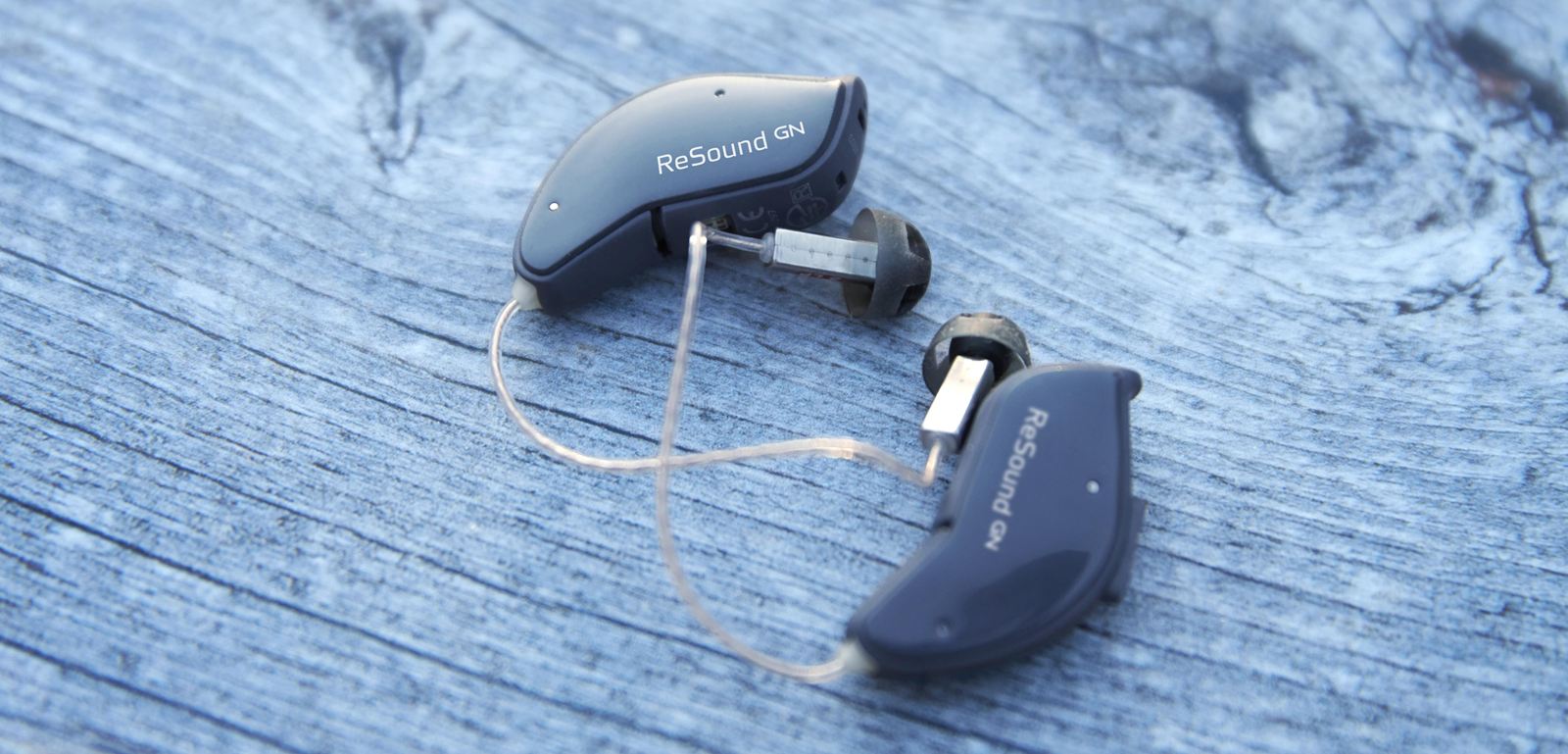Small pair of ReSound hearing aids on a table.