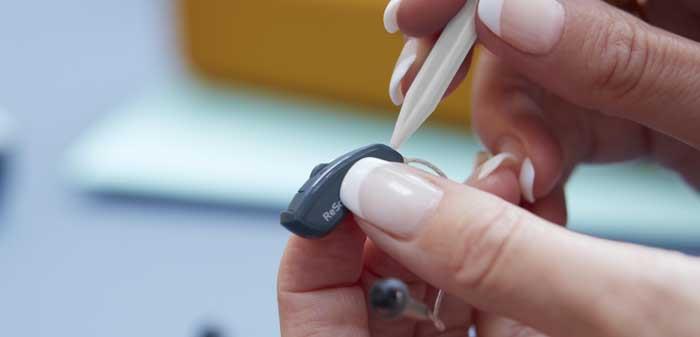 Kvinna som reparerar en ReSound hörapparat.