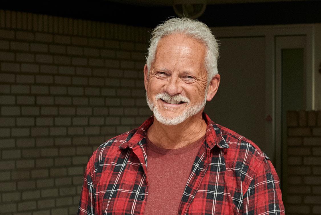 Mulher na praia usando aparelhos auditivos.