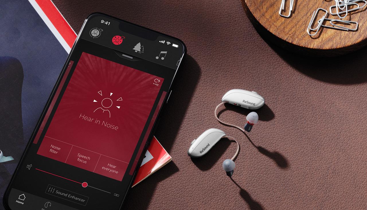 Homme en utilisant l'application ReSound Smart aides auditives.