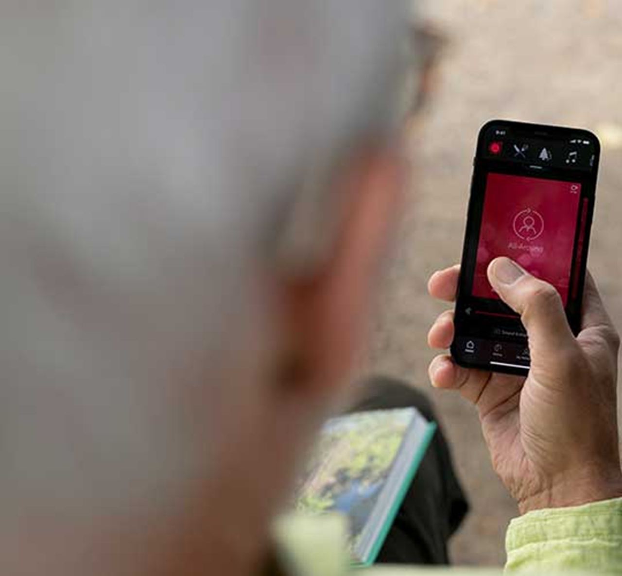 Hombre controlando sus audífonos desde su app ReSound Smart 3D