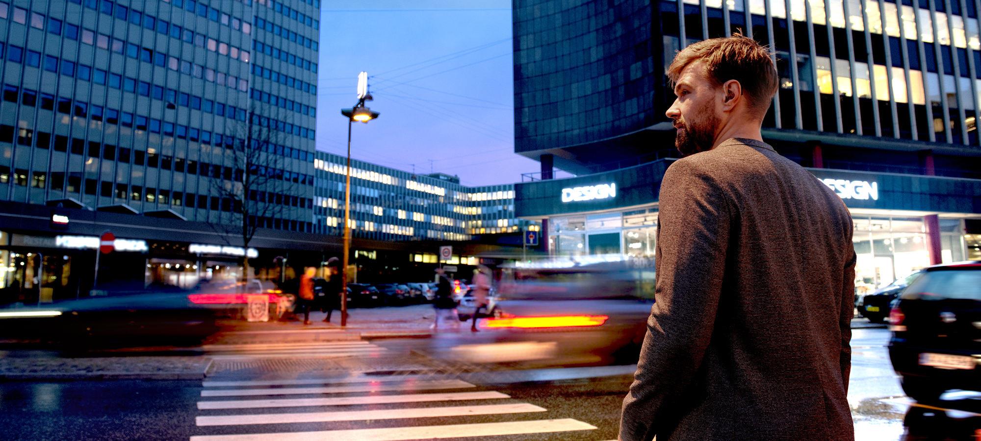 ReSound ENZO Q - Man in ReSound hearing aids crossing the street. 